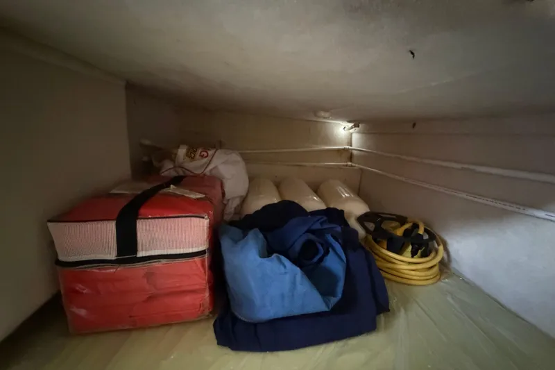 Slide: The Image of Storage compartment in 2004 Bayliner 2452 Ciera Express with life jackets and coiled rope. - 53