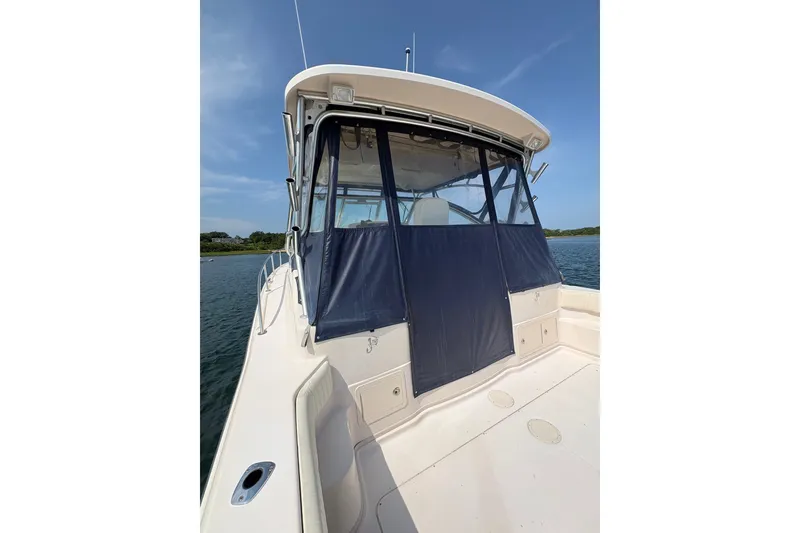 Slide: The Image of 2007 Grady-White Express 360 boat with blue canvas enclosure on calm water. - 33