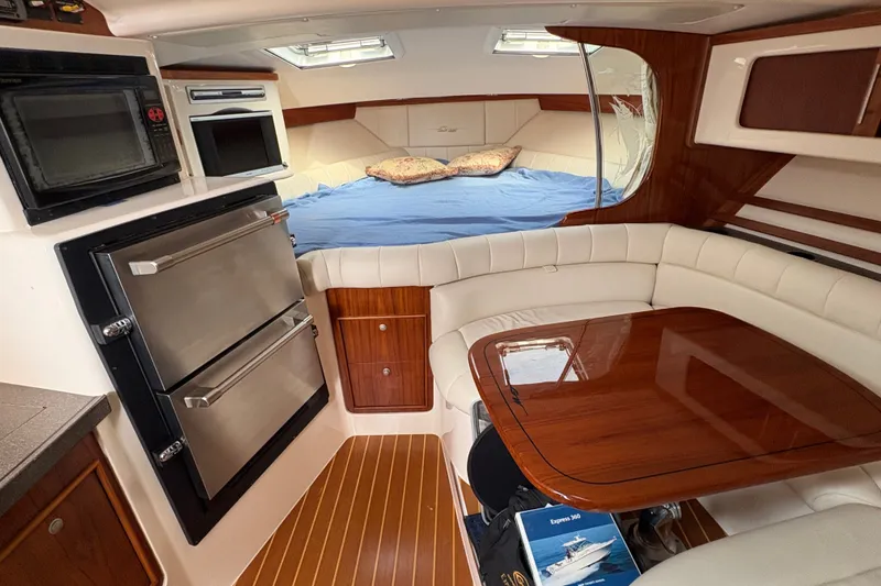 Slide: The Image of Luxurious 2007 Grady-White Express 360 cabin interior with kitchenette, dining area, and cozy bed. - 26