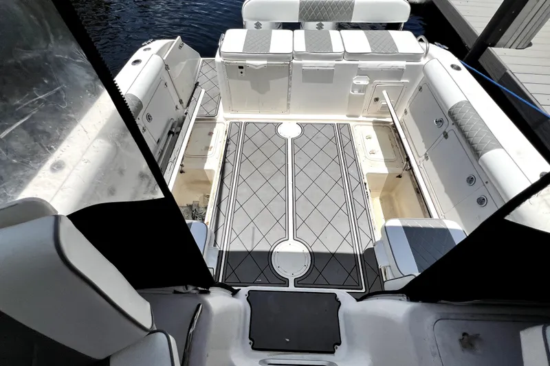 Slide: The Image of 2004 Century 3200 Walk-Around boat interior with cushioned seating and storage compartments. - 62