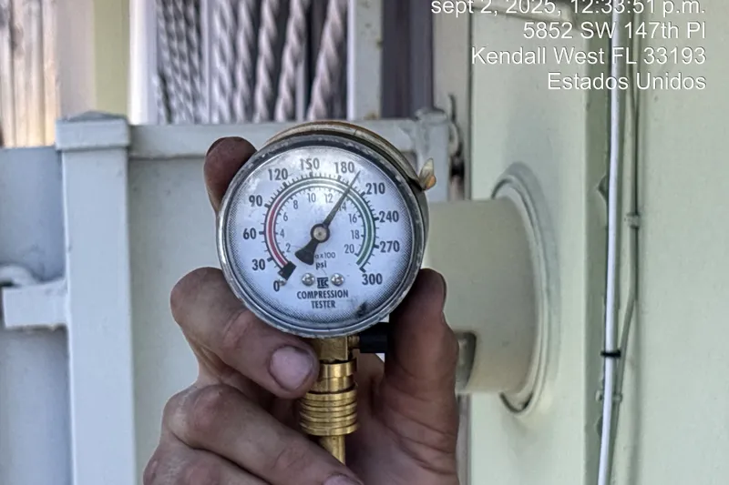 Slide: The Image of Hand holding a compression tester gauge, displaying pressure in psi, near a building exterior. - 59