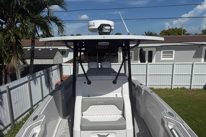 Slide: The Image of 2004 Donzi 29 ZF Open boat with T-top and Garmin radar, parked in a residential yard. - 48