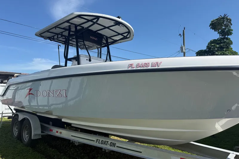 Slide: The Image of 2004 Donzi 29 ZF Open boat on trailer under clear blue sky. - 0