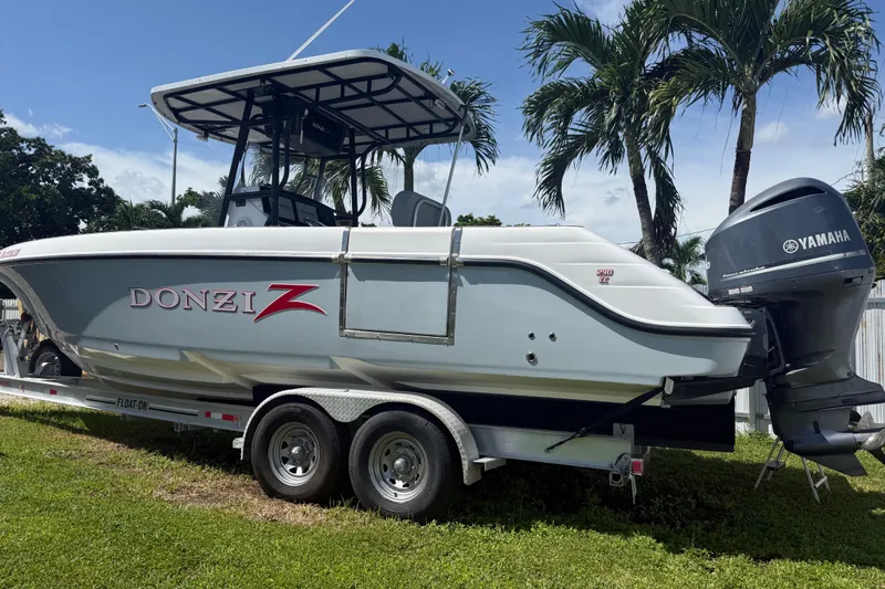 Slide: The Image of 2004 Donzi 29 ZF Open boat on trailer with Yamaha engine, parked near palm trees. - 5