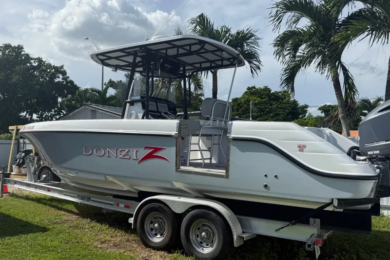 Slide: The Image of 2004 Donzi 29 ZF Open boat on trailer, surrounded by palm trees. - 6