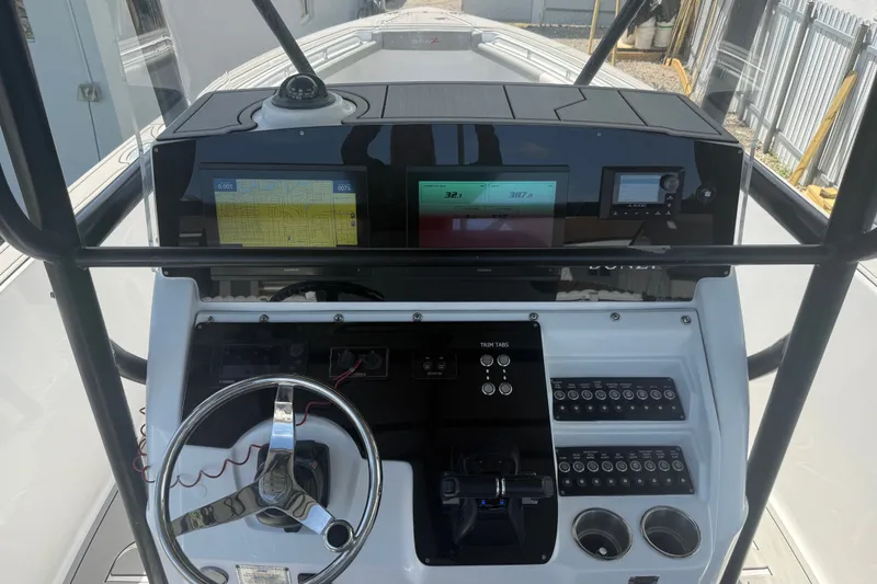 Slide: The Image of 2004 Donzi 29 ZF Open boat dashboard with navigation screens and controls. - 28