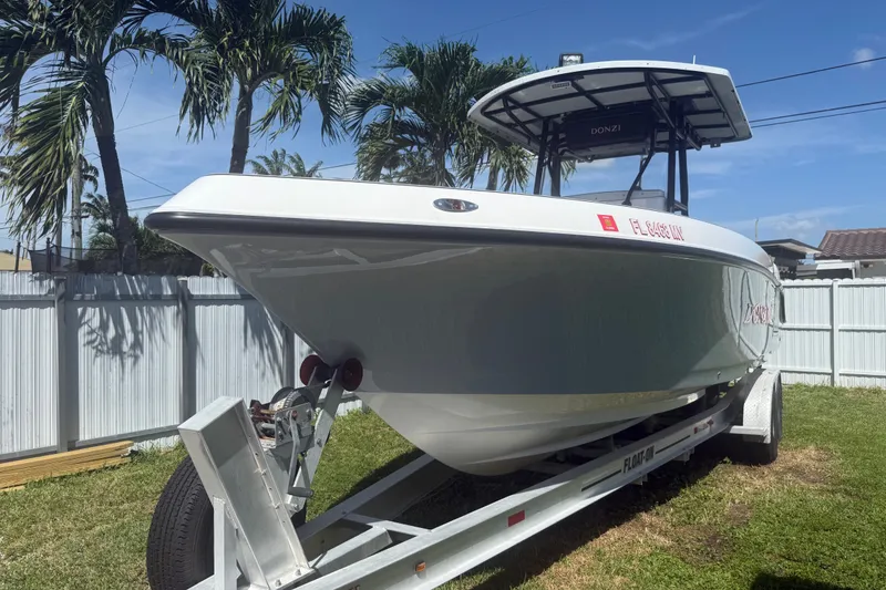 Slide: The Image of 2004 Donzi 29 ZF Open boat on trailer, parked in a sunny yard. - 17