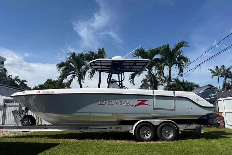 Slide: The Image of 2004 Donzi 29 ZF Open boat on trailer, parked outdoors with palm trees in background. - 4