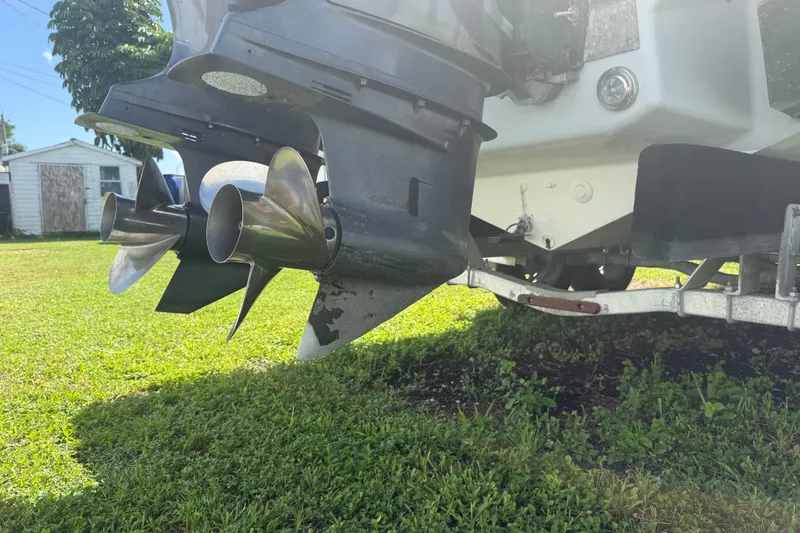 Slide: The Image of 2004 Donzi 29 ZF Open boat propellers on a trailer, parked on grass. - 15