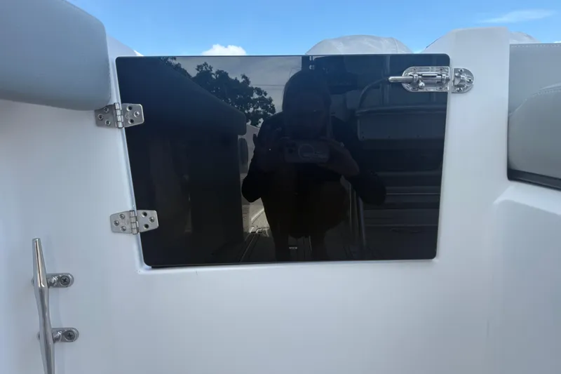 Slide: The Image of 2004 Donzi 29 ZF Open boat hatch with reflective surface and secure hinges. - 25