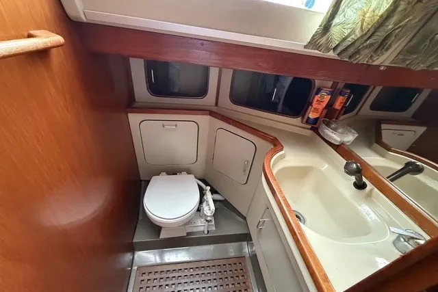 Slide: The Image of 1981 C&C Landfall 38 yacht bathroom with toilet, sink, and wooden accents. - 18