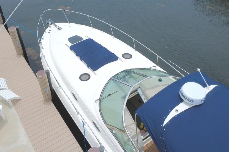 Slide: The Image of 2004 Sea Ray 340 Sundancer yacht docked beside a wooden pier with white chairs. - 7