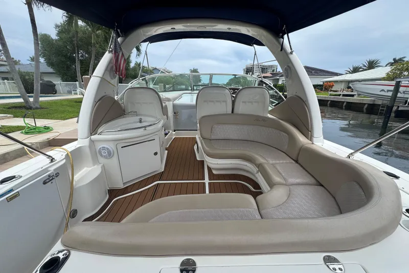 Slide: The Image of 2004 Sea Ray 340 Sundancer boat interior with beige seating and wood flooring. - 10