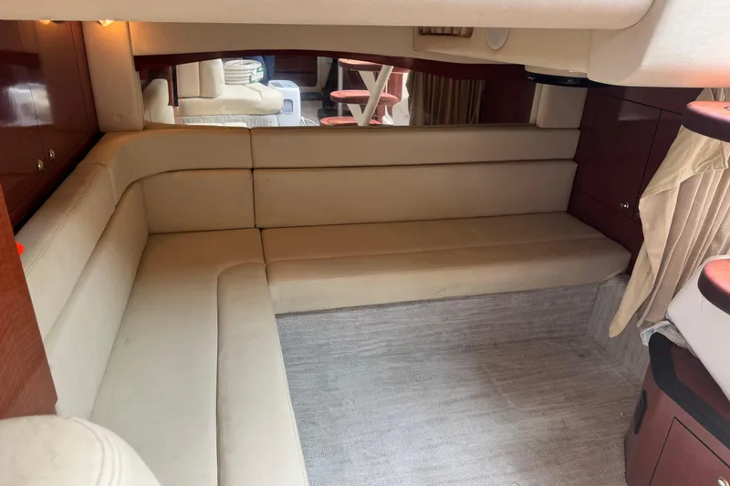 Slide: The Image of 2004 Sea Ray 340 Sundancer interior with beige seating and wooden cabinetry. - 30