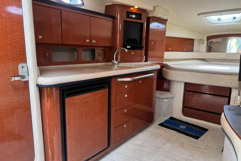 Slide: The Image of Interior of 2004 Sea Ray 340 Sundancer yacht with wood cabinetry and compact kitchen. - 24