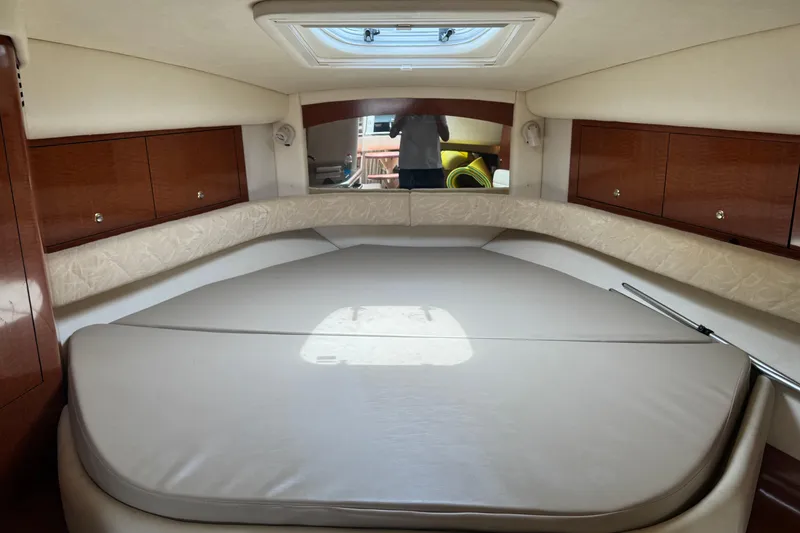 Slide: The Image of Interior cabin of 2004 Sea Ray 340 Sundancer with plush bedding and wooden cabinets. - 23