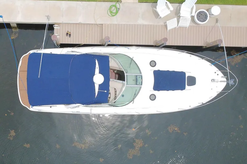 Slide: The Image of Overhead view of a 2004 Sea Ray 340 Sundancer docked by a waterfront patio. - 5