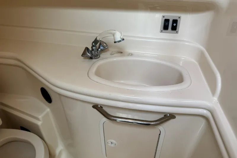 Slide: The Image of 2004 Sea Ray 340 Sundancer bathroom sink with faucet and storage compartment. - 28