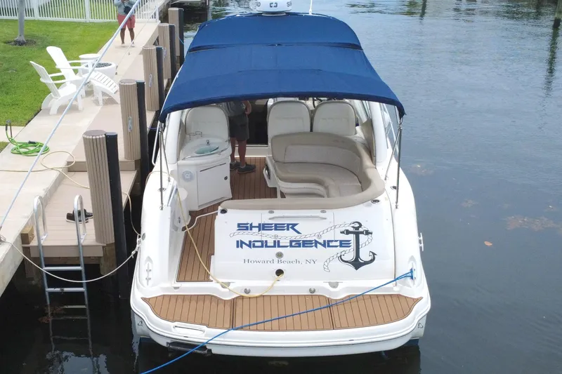 Slide: The Image of 2004 Sea Ray 340 Sundancer docked, featuring "Sheer Indulgence" name, blue canopy, and spacious seating. - 3