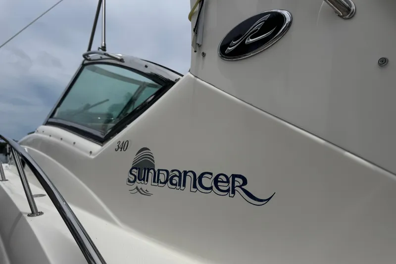 Slide: The Image of 2004 Sea Ray 340 Sundancer boat with sleek design and logo detail. - 9