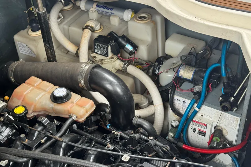 Slide: The Image of Engine compartment of a 2004 Sea Ray 340 Sundancer, showcasing hoses and mechanical components. - 33