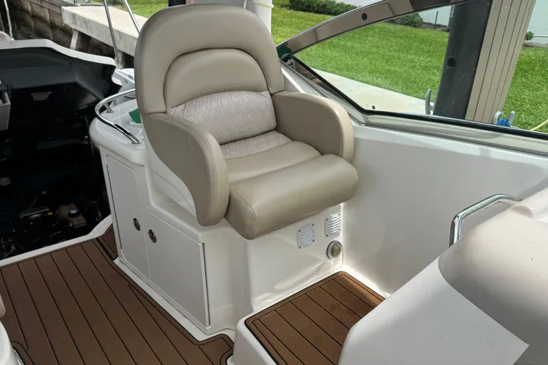 Slide: The Image of 2004 Sea Ray 340 Sundancer cockpit with beige captain's chair and teak flooring. - 19