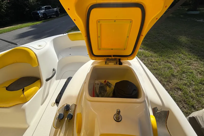 Slide: The Image of 2004 Sea-Doo Sportster LE DI boat with open storage compartment and yellow seating. - 16