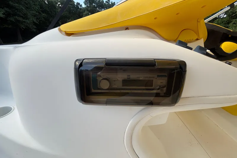 Slide: The Image of 2004 Sea-Doo Sportster LE DI boat dashboard with stereo system, featuring yellow accents. - 27