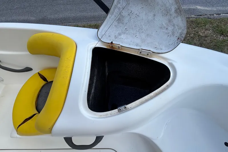 Slide: The Image of 2004 Sea-Doo Sportster LE DI boat with open storage compartment and yellow seating. - 23