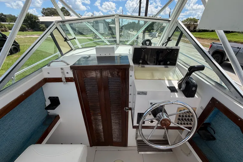 Slide: The Image of 1986 Grady-White Seafarer 226 boat cockpit with steering wheel and control panel. - 15
