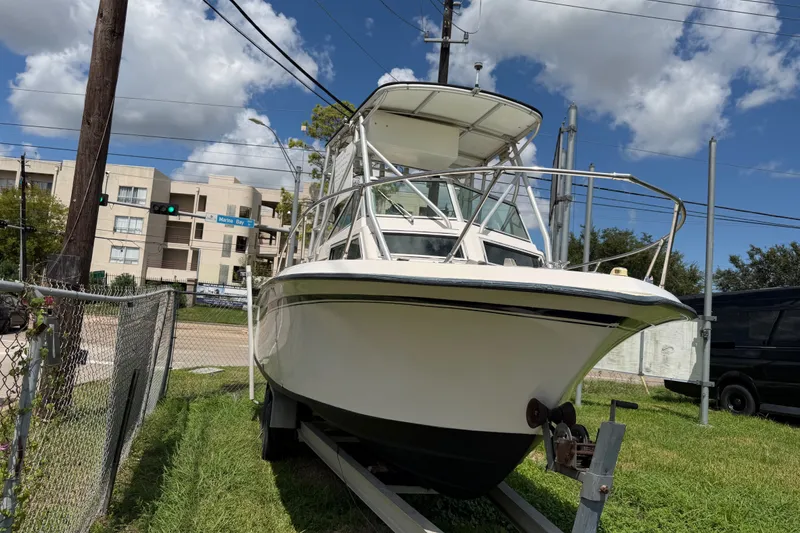 The Image of 1986 Grady-White Seafarer 226 boat on trailer, parked outdoors under a blue sky. - 0