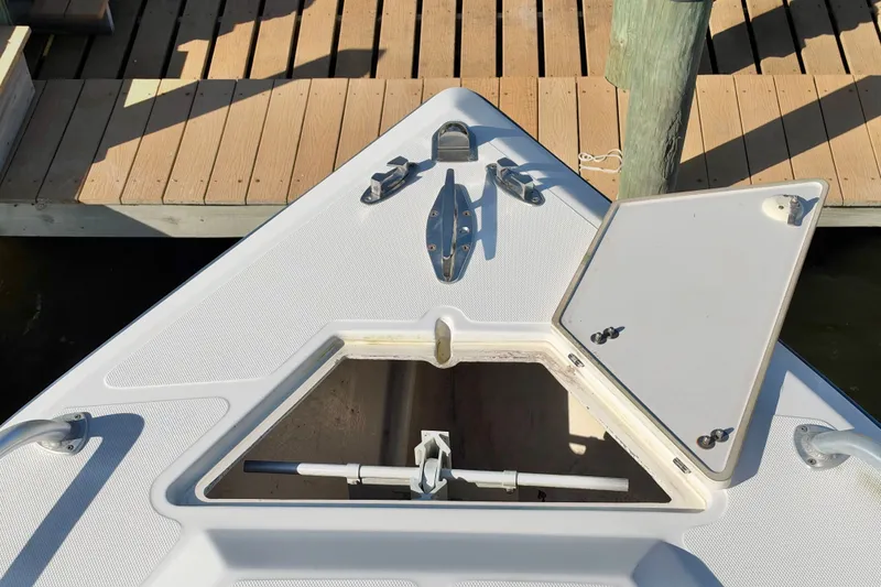 Slide: The Image of Bow of 2004 Venture 34 Cuddy boat with open hatch and dock background. - 34