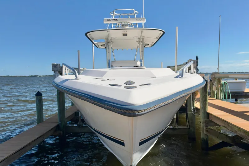 Slide: The Image of 2004 Venture 34 Cuddy boat docked by the water on a sunny day. - 2