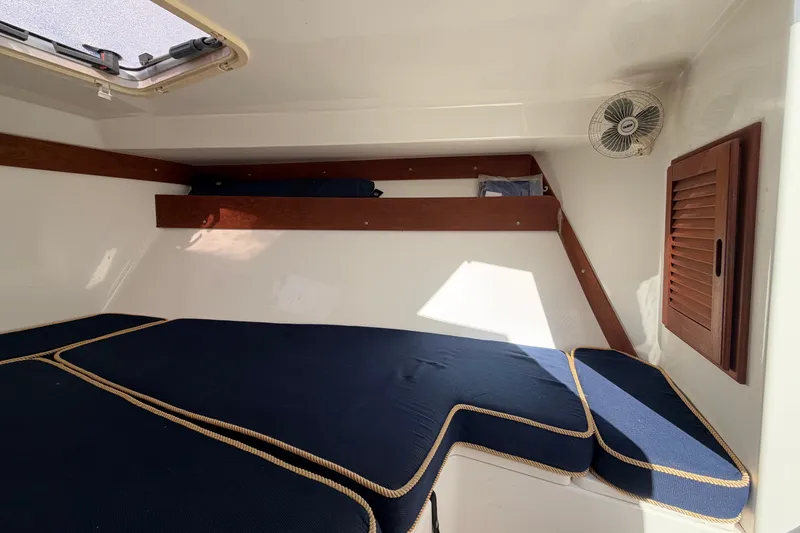Slide: The Image of 2004 Venture 34 Cuddy cabin interior with blue cushions and wooden accents. - 73