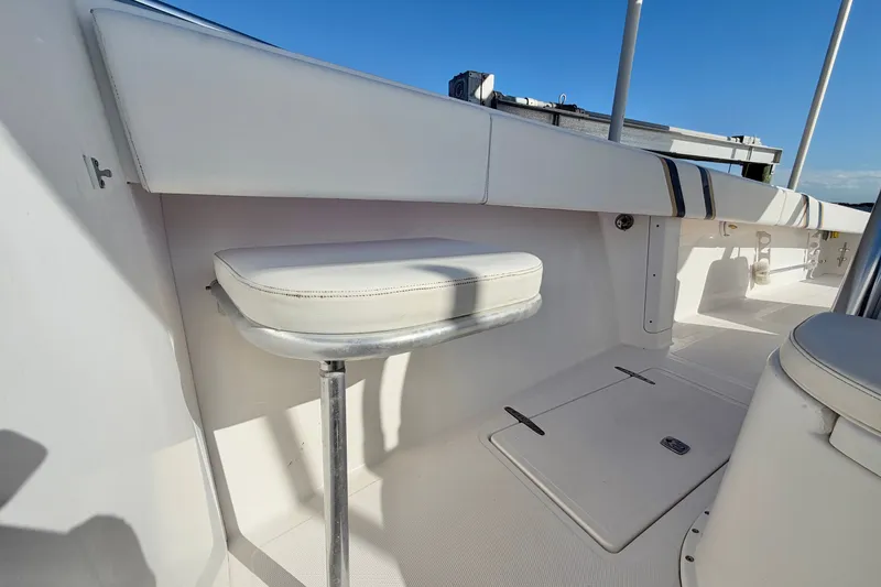 Slide: The Image of 2004 Venture 34 Cuddy boat interior with white seating and storage compartments. - 57