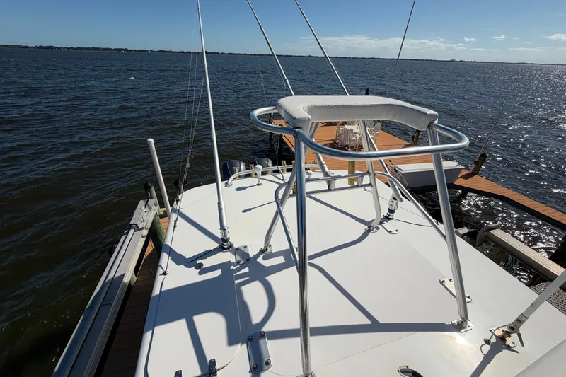 Slide: The Image of 2004 Venture 34 Cuddy boat docked on a sunny day, featuring a raised observation seat. - 91