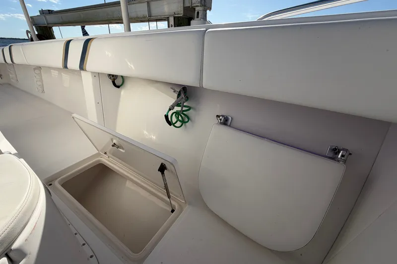 Slide: The Image of 2004 Venture 34 Cuddy boat interior with open storage compartment and cushioned seating. - 61