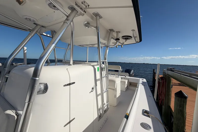 Slide: The Image of 2004 Venture 34 Cuddy boat docked by the water on a sunny day. - 63