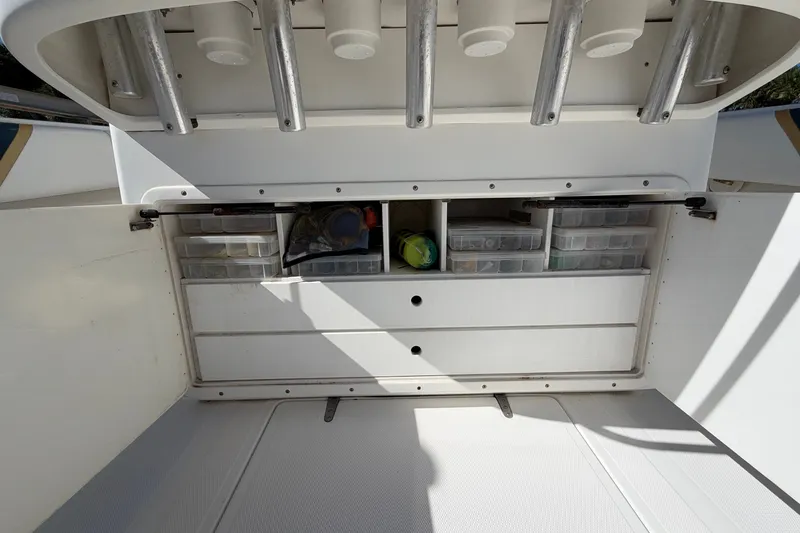 Slide: The Image of Storage compartment on a 2004 Venture 34 Cuddy boat, featuring organized tackle boxes. - 107