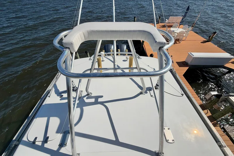 Slide: The Image of 2004 Venture 34 Cuddy boat with tower, docked by wooden pier on water. - 92