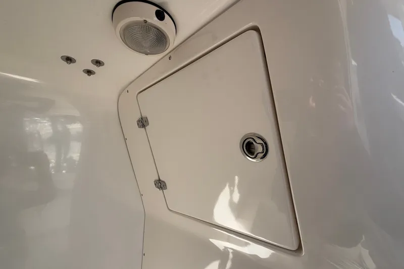 Slide: The Image of 2004 Venture 34 Cuddy cabin interior with storage compartment and light fixture. - 103
