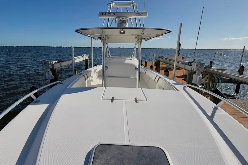 Slide: The Image of 2004 Venture 34 Cuddy boat docked by the water on a sunny day. - 35