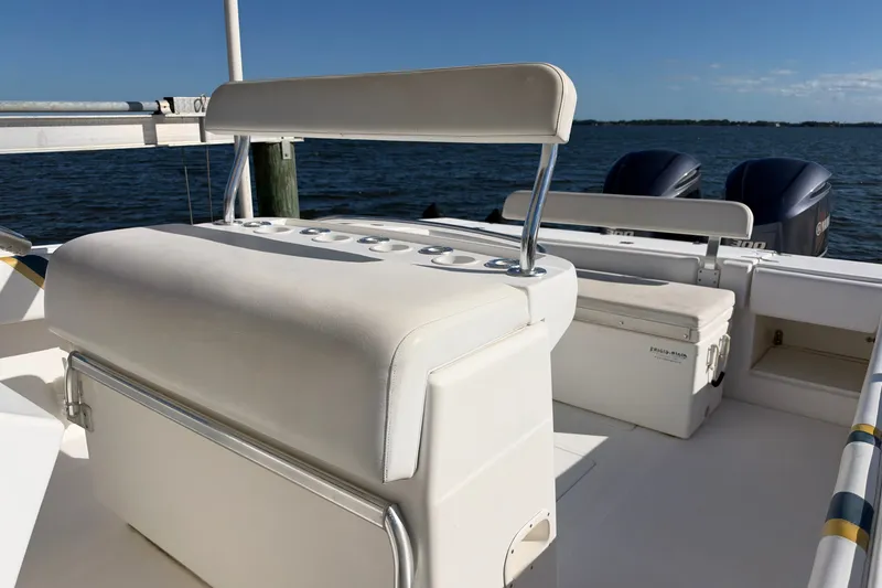 Slide: The Image of 2004 Venture 34 Cuddy boat interior with seating and dual outboard motors. - 64