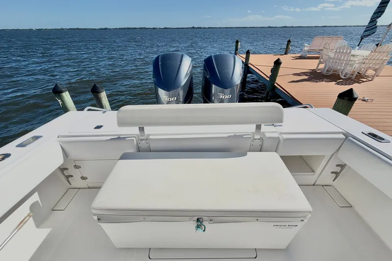 Slide: The Image of 2004 Venture 34 Cuddy boat with twin 300 horsepower engines docked by the water. - 76