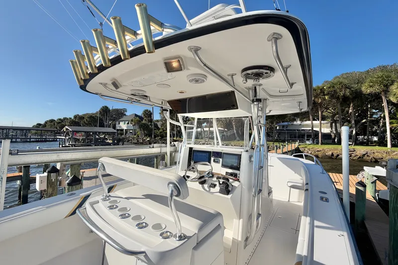 Slide: The Image of 2004 Venture 34 Cuddy boat interior with helm, docked by waterfront homes. - 25
