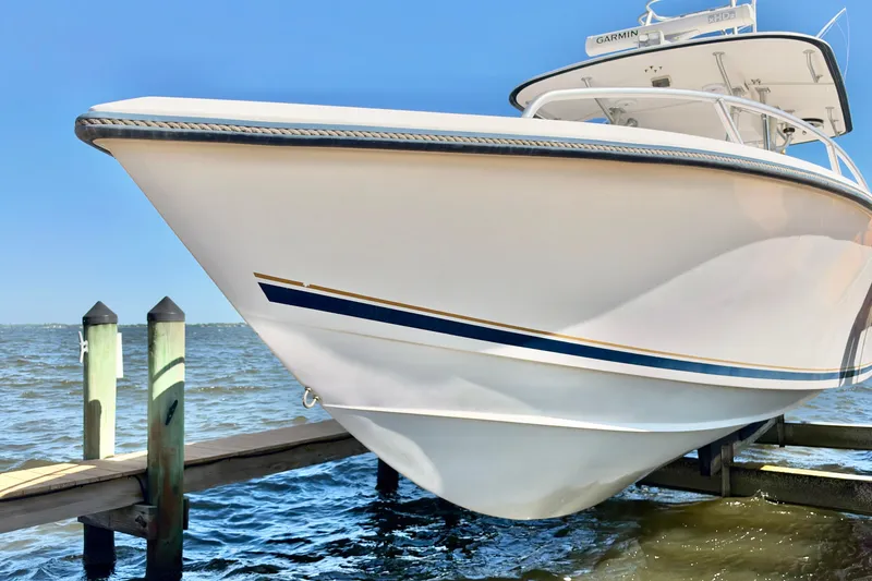 Slide: The Image of 2004 Venture 34 Cuddy boat docked by the water on a sunny day. - 4