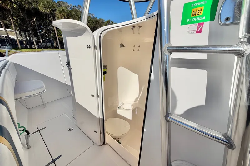 Slide: The Image of 2004 Venture 34 Cuddy boat interior with open bathroom door and Florida registration sticker. - 39