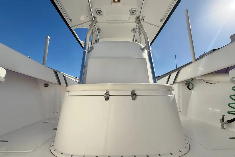 Slide: The Image of 2004 Venture 34 Cuddy boat interior with seating and storage, under clear blue sky. - 54
