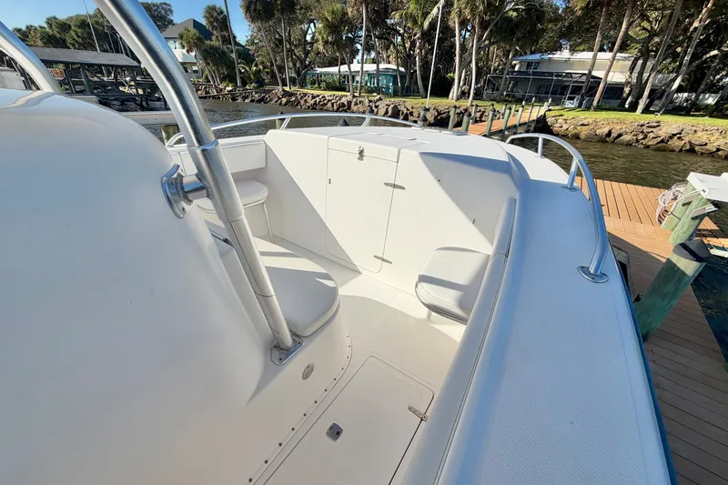 Slide: The Image of 2004 Venture 34 Cuddy boat interior with seating and storage, docked by a scenic waterfront. - 30