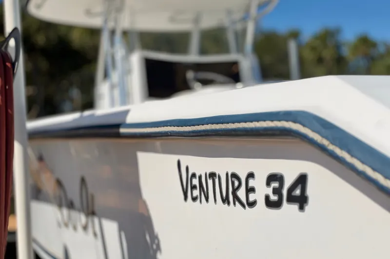 Slide: The Image of 2004 Venture 34 Cuddy boat with visible name and sleek design. - 9